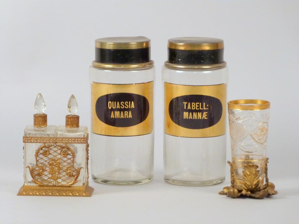4 Glass and Brass Tone Kitchen Articles: Comprising two glass canisters, an oil and vinegar, and a mounted cup.