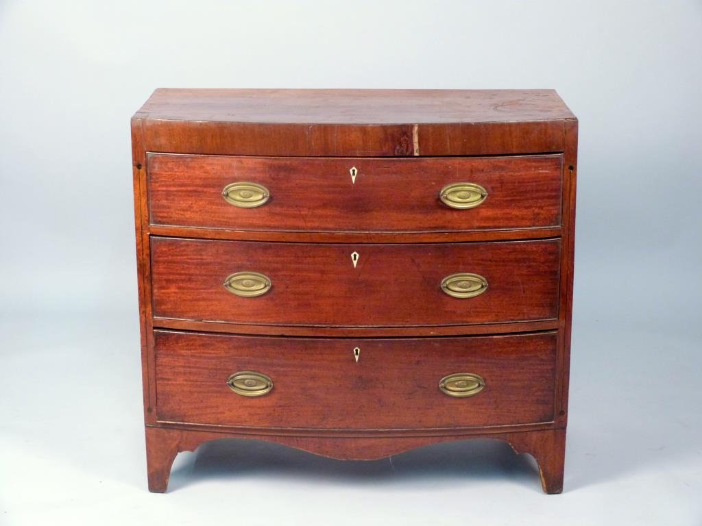 Antique English Bow Front Chest: Three drawers, ebony line inlay, and inlaid bone escutcheons, 39" W x 19 1/2" D x 35 1/2" H, loss to veneer upper front, spitting to sides.