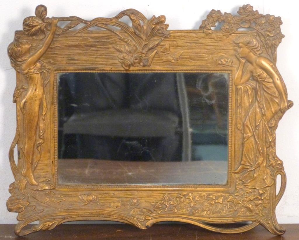 Art Nouveau Bronze Table Top Easel Mirror: Mirror design flanked by female figures. Hinged stand base stamped "Made in USA".11 1/2" H X 14 1/2" W.