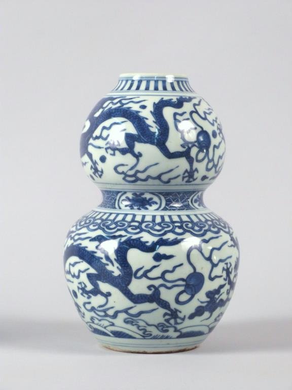 Chinese Blue & White Double Gourd Vase: Porcelain body decorated with underglaze blue depicting dragons amid clouds and fire balls. 9 1/2" H.