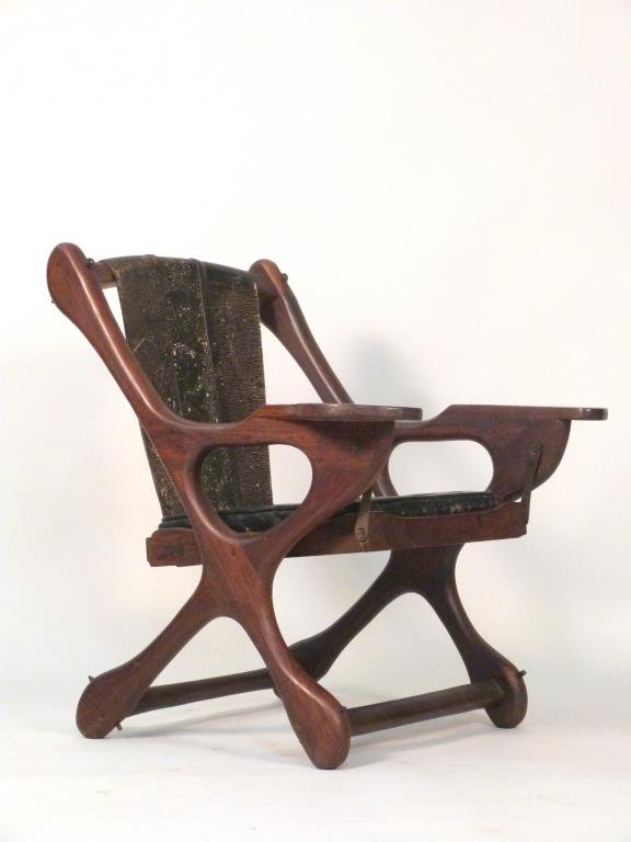 Don Shoemaker Sling Swinger Chair: Sculpted wood frame with sling leather back and leather slip seat. 31" W X 31" D X 32" H. Leather as is, wood in need of restoration.