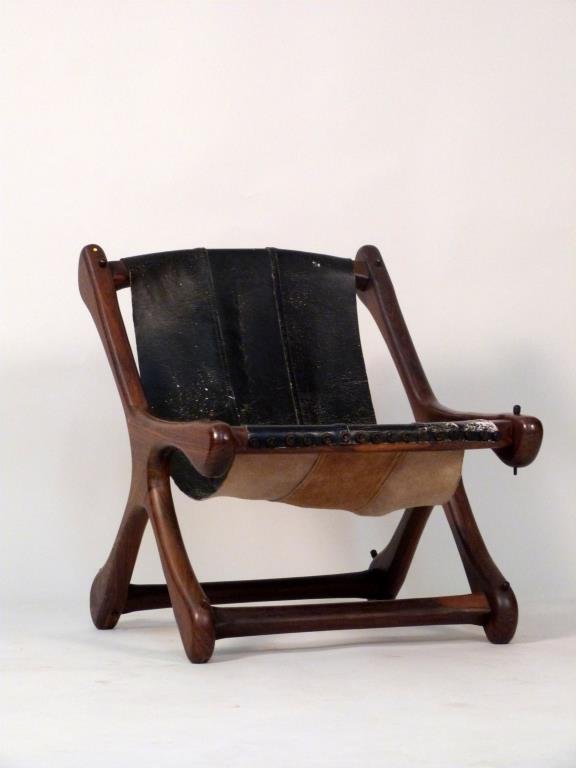 Don Shoemaker Sling Chair: Sculpted wood frame with sling leather upholstery. 23 1/2" W X 26" D X 27" H. Leather as is.