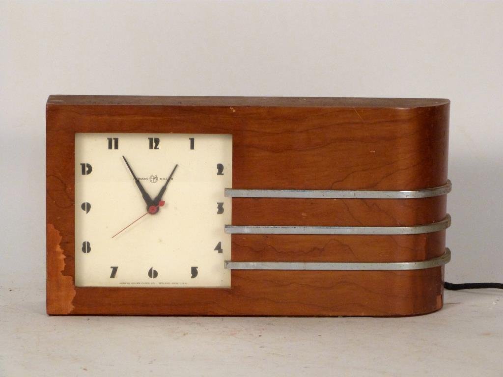 Gilbert Rohde for Herman Miller Clock: Wood veneer and chrome plated-steel. 13" W X 7" H. Several areas of loss to veneer, in need of restoration. For World's Fair Clocks.