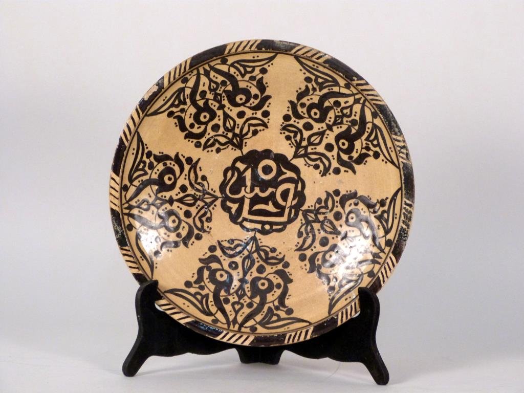 Persian Ceramic Wall Plate: Ceramic, straw color glaze with dark brown decoration. 12 1/2" D. Some losses to glaze.