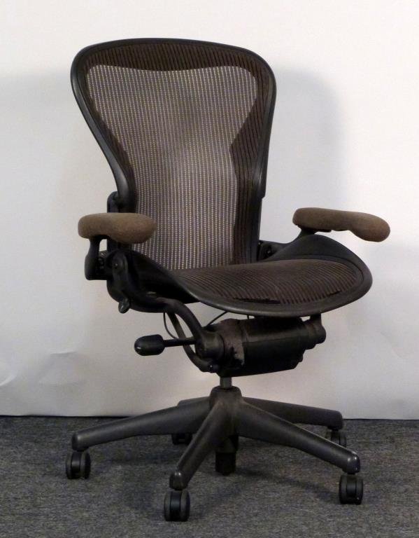 Herman Miller Aeron Chair: Brown mesh seat and back, with adjustable arms. 27" W X 24" D. Scuff to back, tears to seat. (From an East Side Townhouse)