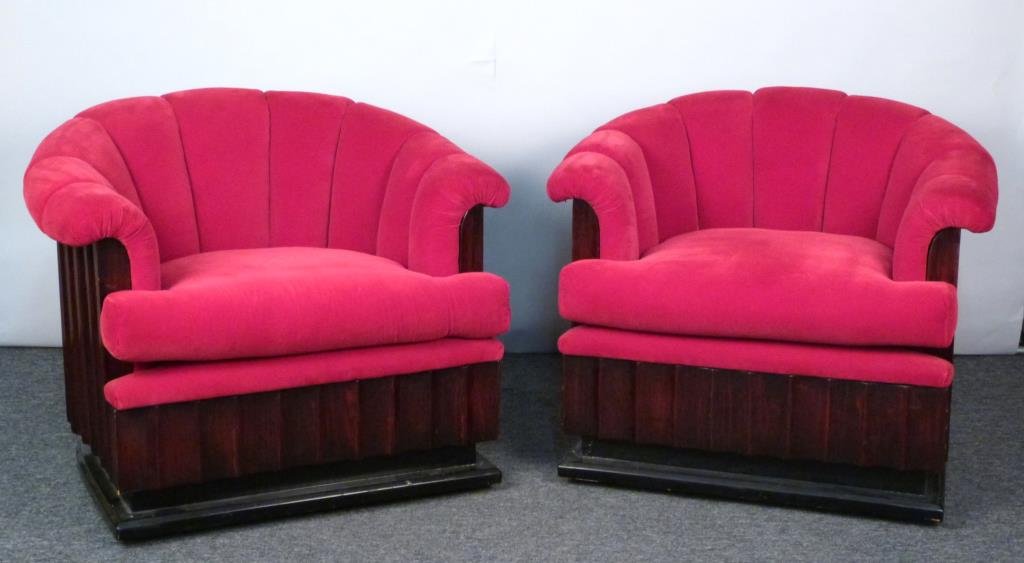 Pair of Art Deco Style Club Chairs: Ribbed wood frames with ebonized wood base, Pinkish red velveteen channel upholstery, on casters. 31" W X 31" D X 31" H. Hollywood Regency Chairs. These belong in a house .......
