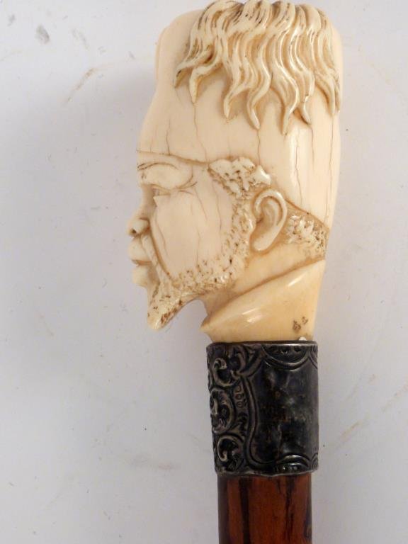 African Cane With Caved Bone Head: With figured wood shaft and silver collar. 35 1/2" H. (Prospect Park Brooklyn Property)