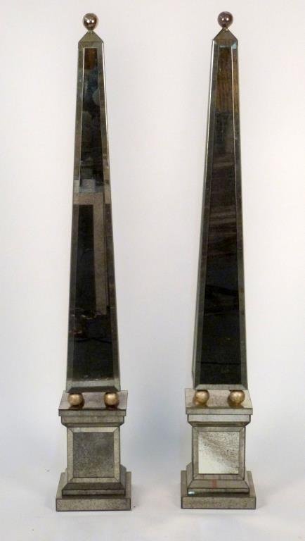 Pair of Large Mirrored Obelisks: Mirror framed sides, with ball finials, on stepped bases. As is. 64" H. As is - One has cracked applied panel on base trim.