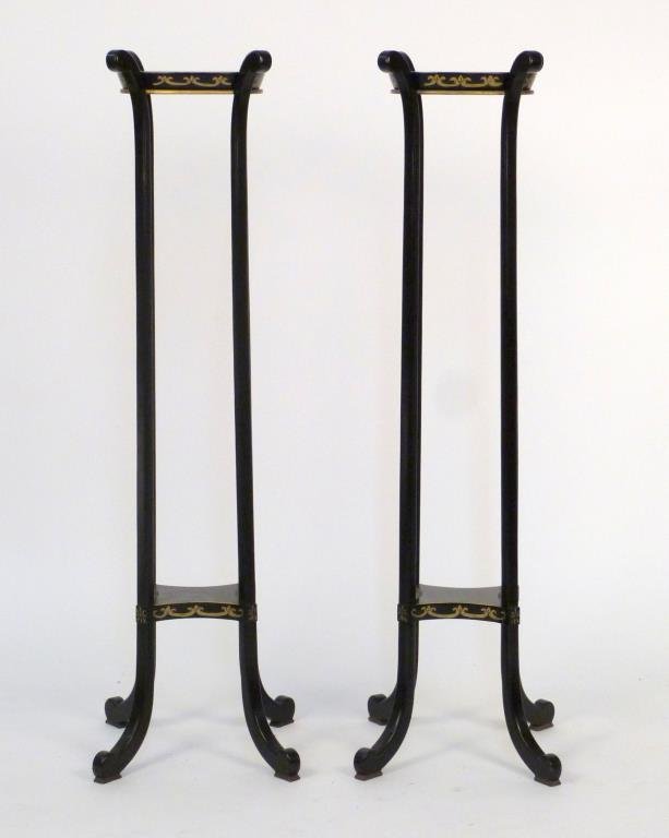 Pair of 2 Tier Urn Stands: Ebonized wood with gilt painted accents, on splayed legs. 49" H X 11" W X 10" D.
