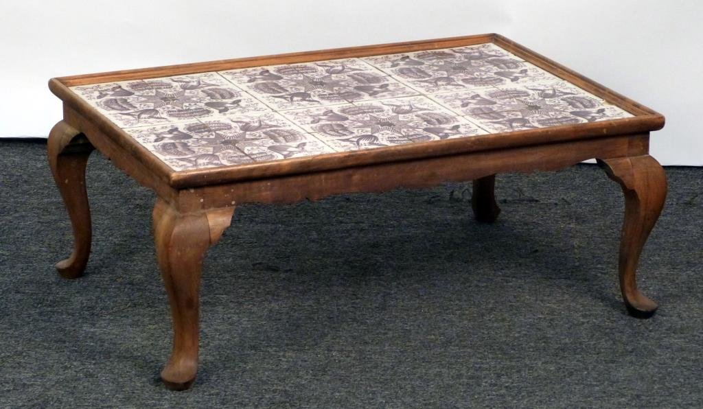 Delft Tile Top Cocktail Table: On a Queen Anne style carved wood base. 33" W X 22"D X 13 1/2" H. As is.