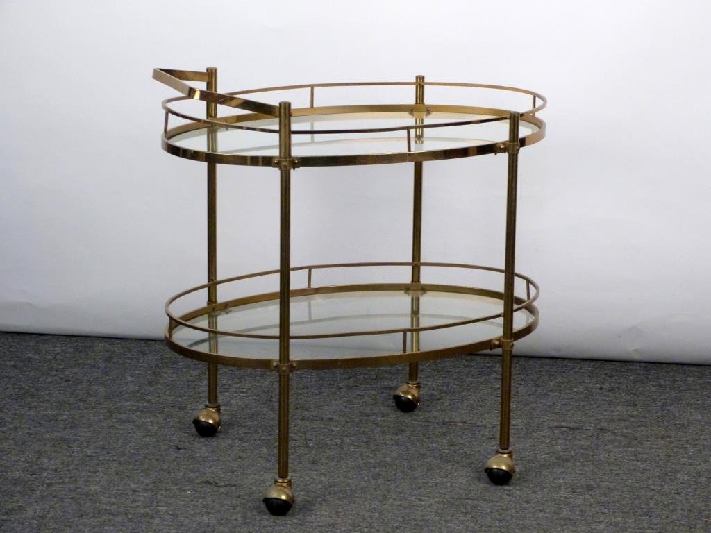 2 Tier Brass and Glass Serving/Bar Cart: Oval galleried tiers with inset glass, on casters. 30" W X 19 1/2" D X 31" H. Brass needing some restoration.
