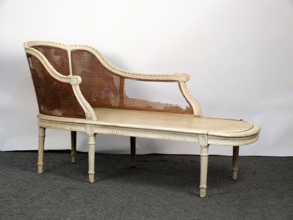 Louis XVI Style Chaise Lounge: Carved wood frame with fluted legs, double caned. 25" W X 64" D X 34 1/2" H. As is.
