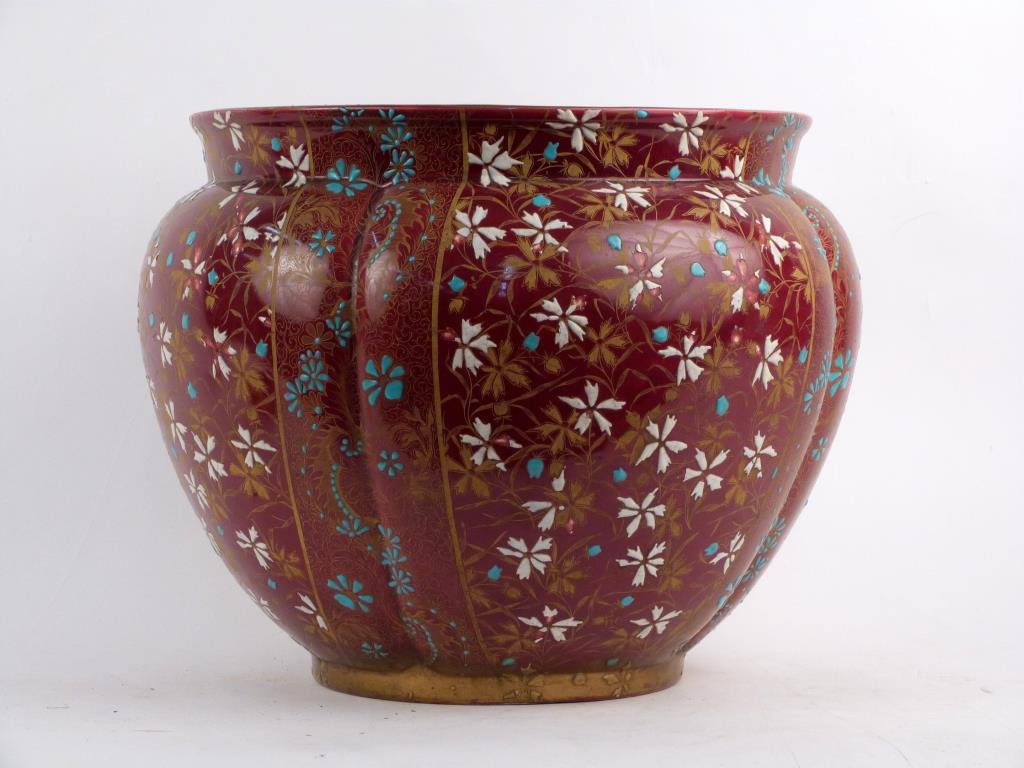 Continental Porcelain Jardiniere: Lobed bulbous form with ox blood glaze and gilt and enamel decoration depicting floral spray. 13 1/2" H X 17" D. As is.