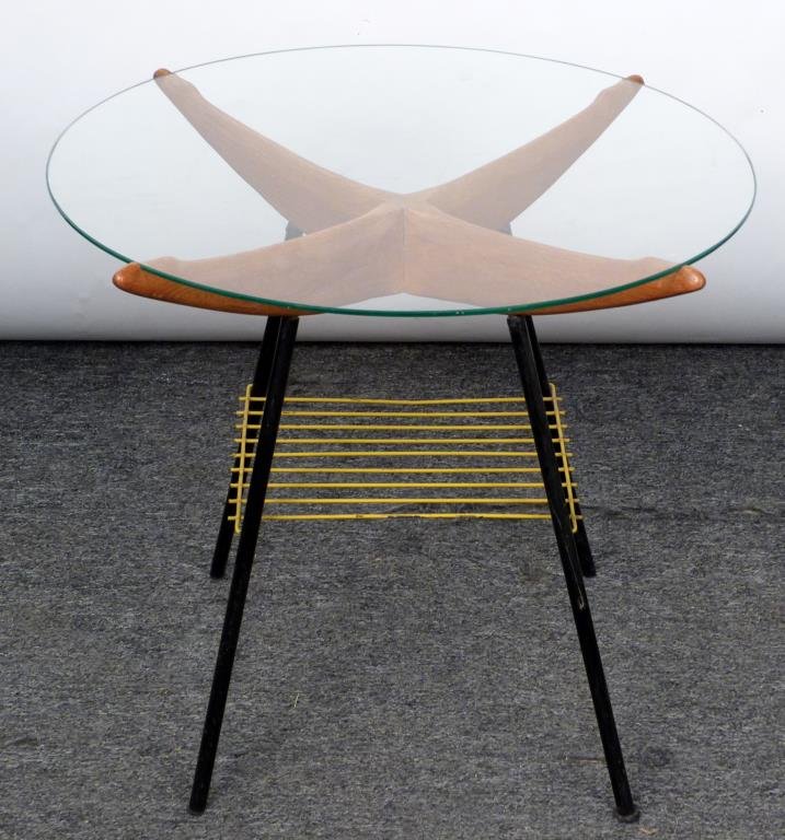 Mid-Century Wood and Iron Side Table: Ends of wood frame fitted to support round glass top, ebonized legs, yellow shelf. (145 Central Park West Estate)