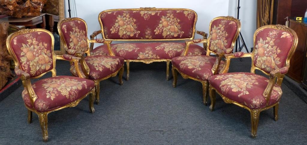 5 Piece Louis XV Style Salon Suite: 4 fauteuils, 1 settee, all with gilt carved frames and upholstered seats and backs. Fauteuils: 27 W X 29 D X 38 H; settee: 68 W X 33 D X 37 1/2 H. Arm damages. As is.