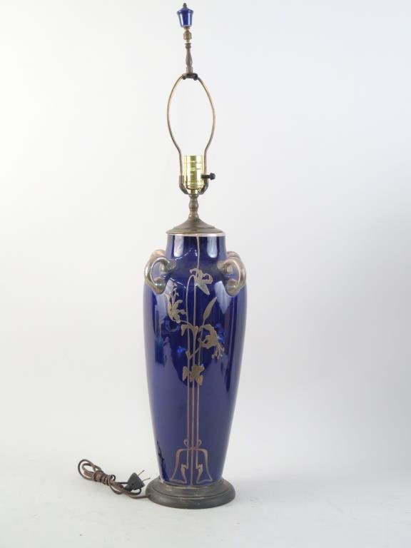 Art Nouveau Vase Mounted as a Lamp: Prussian blue glaze with silver overlay and handles. 23.5 H to socket, 34" H to finial. Losses to silver."