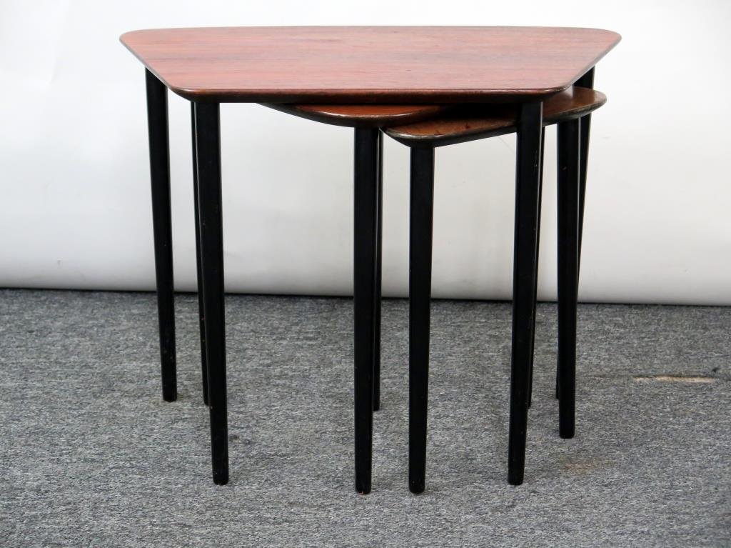 Nest of 3 Dunbar Style Tables: Trapezoidal and triangular rosewood, on round ebonized and tapered legs. Largest: 23.5 W X 13.75" D X 18.75" H."