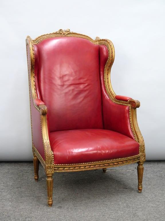 Louis XVI Style Wingback Bergere: Red vinyl upholstered and studded. Gilt carved fluted and tapered legs. 28W X 29"D X 45"H"