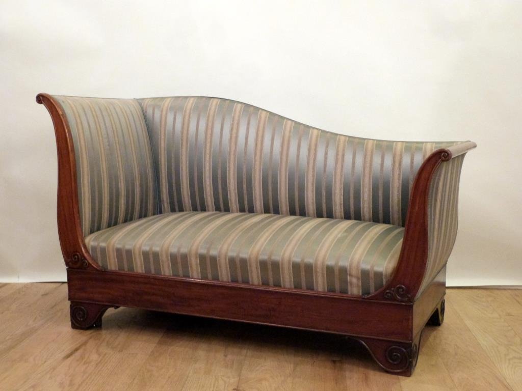 Biedermeier Mahogany Divan / Chaise: Upholstered with scroll arms and scroll designs on feet. High left sloping to lower right. Stains on seat as shown. 57.5W X 26"D X 32.5"H"