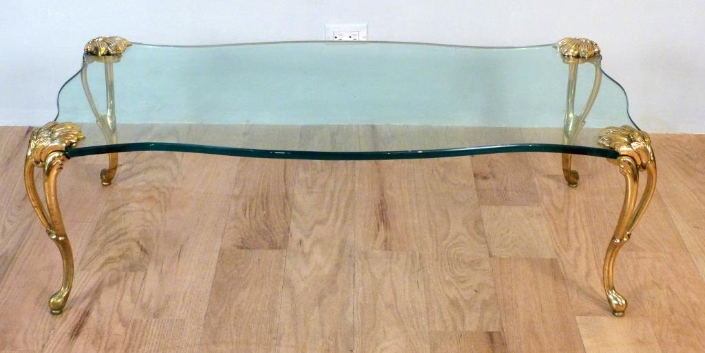 Art Nouveau Style Bronze Leg Cocktail Table: Bronze legs screwed onto thick serpentine glass top. Rounded edge glass. After P. E Guerin. 48"W X 20"D X 16"H. From a 50 year old collection in Riverdale, NY.