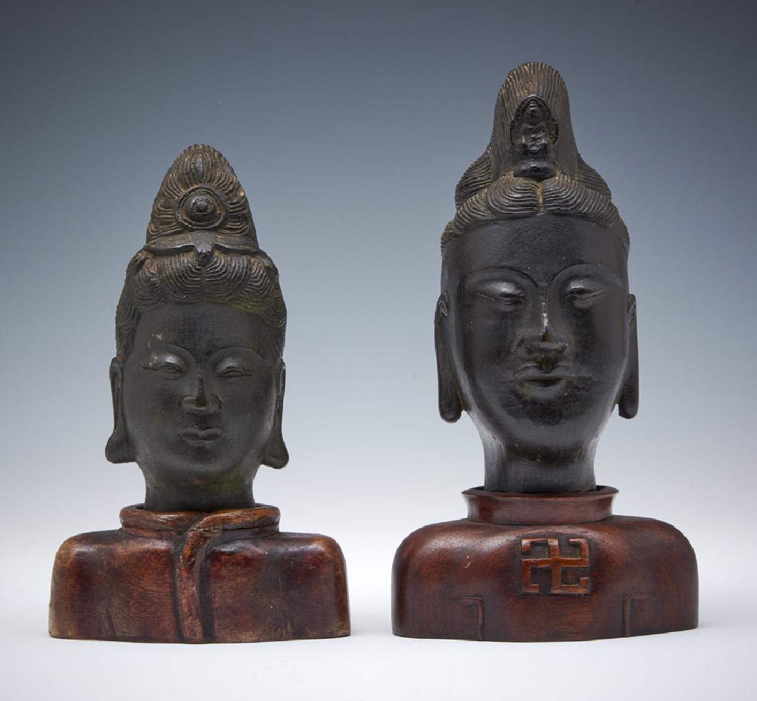 Grouping of two bronze Buddha heads on wood stands (1 of 3)