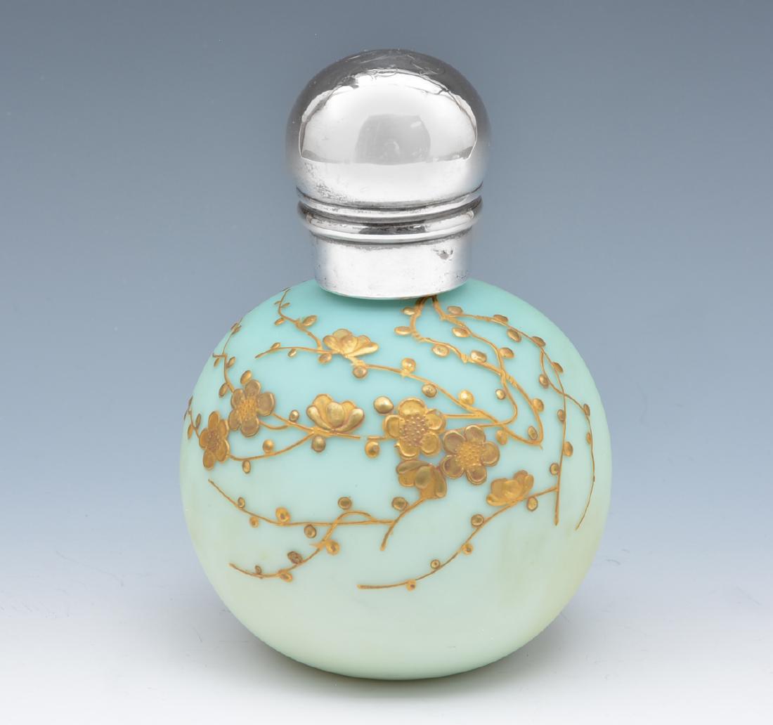 Thomas Webb perfume bottle with gilt design: Thomas Webb blue-to-cream perfume bottle with gilt design. The lid marked for English sterling silver. Measures appx 5" t. Bottle apparently unmarked. In good condition.