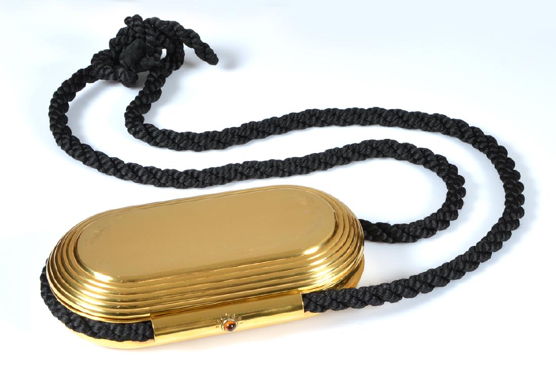 Bulgari evening clutch, gold over sterling silver: Bulgari evening clutch with braided, black cord strap; gold over sterling silver, marked on interior "Bulgari 925 Sterling BD 486" with bezeled jewel clasp, beveled mirror in interior, 6 1/2" x 3 1/2"