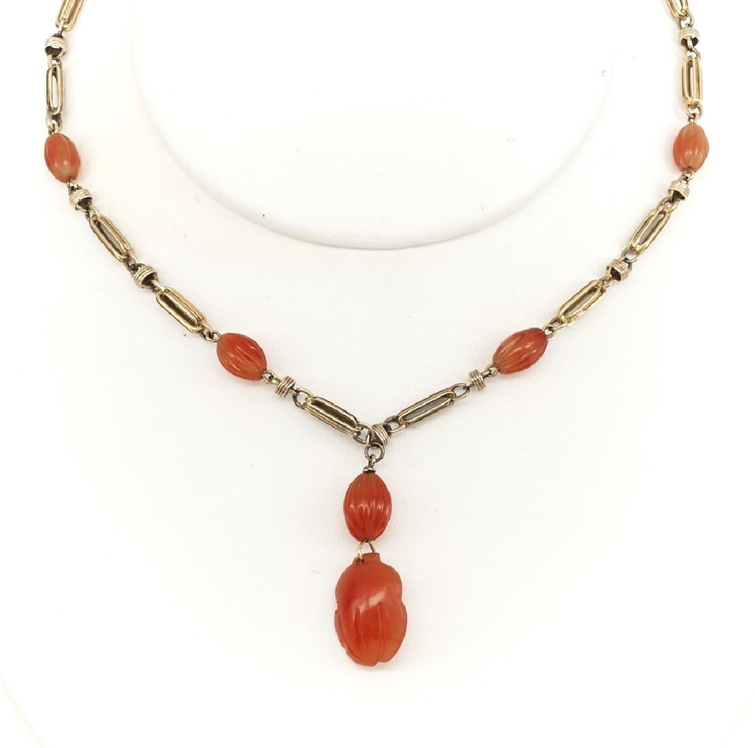 14k gold carved carnelian necklace: 14k Yellow gold carved carnelian necklace, appx. 11mm carved carnelian beads, 16" with a 14mm x 38mm pendant drop, 19.4g.