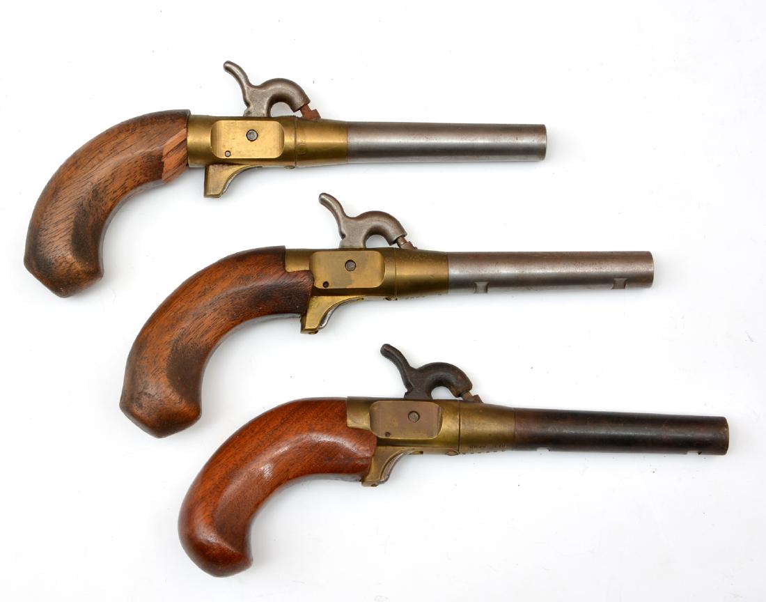Three Percussion Caps Boot Pistols: Pair of single shot percussion cap pistols, 9 1/2" l, good original condition. Single shot percussion cap pistol, replaced stock, stamped CMC 42995A Pat. Pend., 9" l, good original condition.