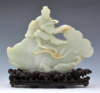 Chinese Large Jade Centerpiece Carving on Stand: Chinese Large Jade Centerpiece Carving on carved wooden stand. Carved jade figure riding a oversized fish on an elaborately carved wooden stand depicting Waves. Jade: 7" tall x 9" wide; Height on stan