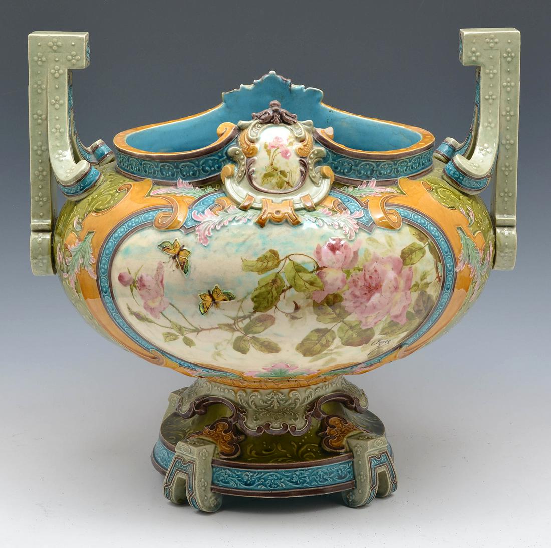 Grand Majolica Floral Decorated Jardiniere: Grand Majolica Floral Decorated Jardiniere with Butterflies. 17"t x 17 3/4"w x 15"d. Signed "C. Roger", Bottom incised with "1106" and an illegible mark. Good condition with small chip at base rim as 