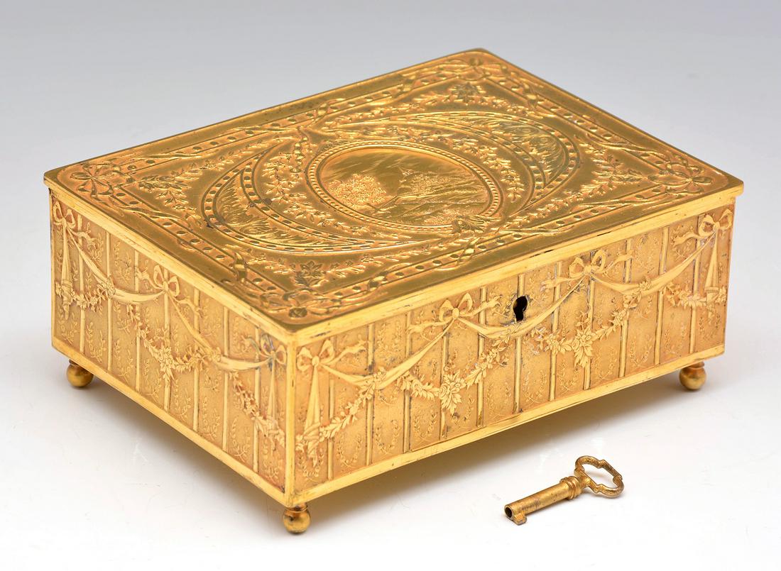 French Gilt Jewelry Box with key.: French Gilt Jewelry Box with key and designs in relief. 2 1/2"t x 6 1/4"w x 3 1/4"d. Very good condition.
