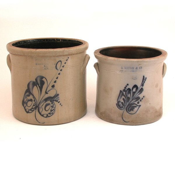American Stoneware Crocks; E Norton, Frank Norton: CROCKS. Two Norton American stoneware crocks, each a pale grey, the first a two gallon crock impressed E Norton & Co, Bennington VT above the numeral 2 and a vibrant cobalt blue flower, good condition