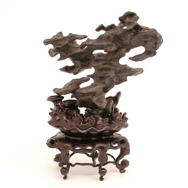 Chinese Scholar's Rock; Ling Bi & Rosewood Stand: SCHOLARS ROCK. Chinese scholar's rock or Ling Bi, with a very complex form, seated on a Chinese rosewood stand, also complex in design and created to fit the rock it holds, very good condition, 7 1/2"