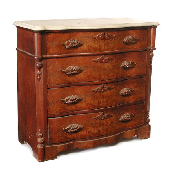 Victorian Walnut Marble Top chest Of Drawers: CHEST. Victorian marble top chest of drawers, the serpentine front set with four drawers, each covered in burlwood veneer and grape bunch handles with carved escutcheons at the center, the drawers are