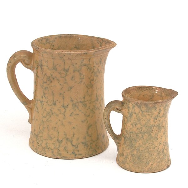 2 Attractive Yelloware Pitchers: PITCHERS. Two attractive yelloware pitchers; a creamer and a buttermilk, each with blue spongework and graceful ear handles, good condition, minor loss, hairline, to smaller piece, largest 6 1/4" h.