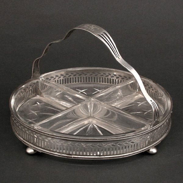 Tiffany & Co. Sterling & Crystal Condiment Server: SERVER. Tiffany & Co. sterling silver and crystal condiment server, the circular sterling frame has a pierced gallery with colonnade and laurel leaves with beaded frames above and below, the shaped ha