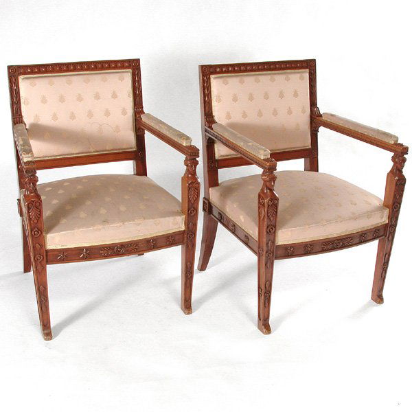 French Walnut Empire Armchairs, Early 19th. C.: ARMCHAIRS. Pair of French Empire walnut armchairs, the square frame carved at the top back with a frieze of standing leaves and a spray of leaves down the sides, the arms are carved with dentils benea