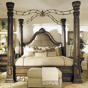 Marge Carson "Bordeaux" Bed: BED. Marge Carson bed from the "Bordeaux" collection, of grand size, the shaped headboard surmounted by a shell and upholstered, each of the four corners has a stately carved urn topped column connect