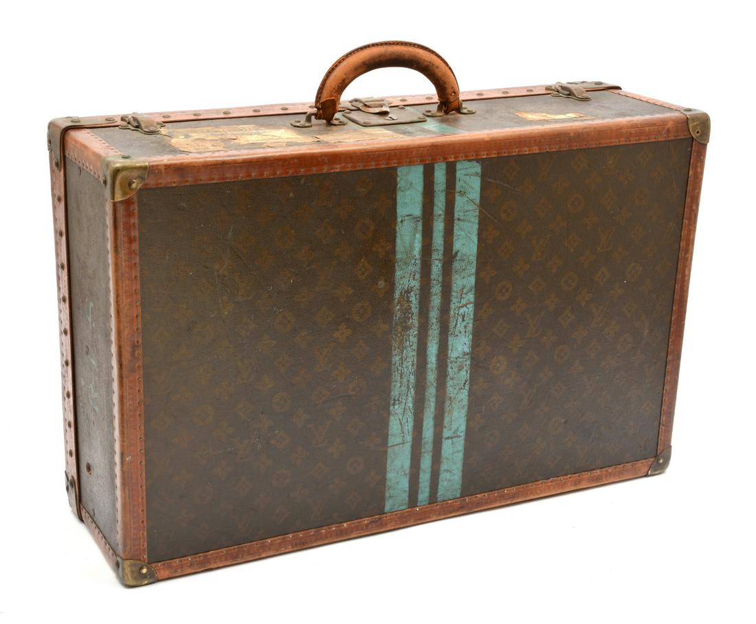 Louis Vuitton hard sided canvas suitcase: Louis Vuitton hard sided canvas suitcase with initials "R.L.S.", a Warwick Hotel shipping label and original Louis Vuitton interior label with serial number 815553, 8 3/4" h x 26" w x 16 1/2" d, in go