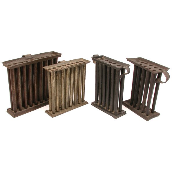 4 19th. Century American Tin Candle Molds: MOLDS. Four American tin candle molds, all tall, with handles and bases, ranging in size from eleven to eighteen candle molds, good condition, eleven candle mold has one form missing, largest 11" t.