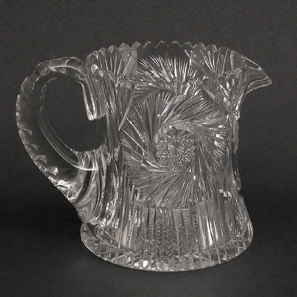 Fine American Brilliant Cut Crystal Pitcher: PITCHER. Fine American brilliant cut crystal pitcher, the flared body with two complex pinwheels alternating with lattice panels with a concave sphere, the handle fully decorated with thumbprint patte