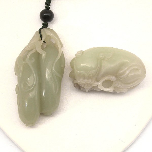 Chinese Jade Carving Toggles, L. 19th. C.: TOGGLES. Two Chinese jade carving hand toggles; the first carved as a pair of melons growing from leafy veins with curling tendrils, the second carved as a recumbent fu-lion with legs tucked beneath t