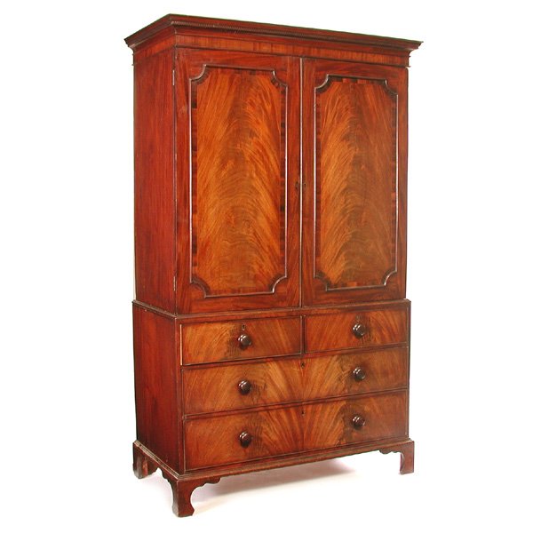 Flame Mahogany Linen Press: LINEN PRESS. Early 19th c. flame mahogany linen press with dentil molded cornice above two molded panel doors with linen tray interior, the lower section has two over two drawers rising on bracket fee