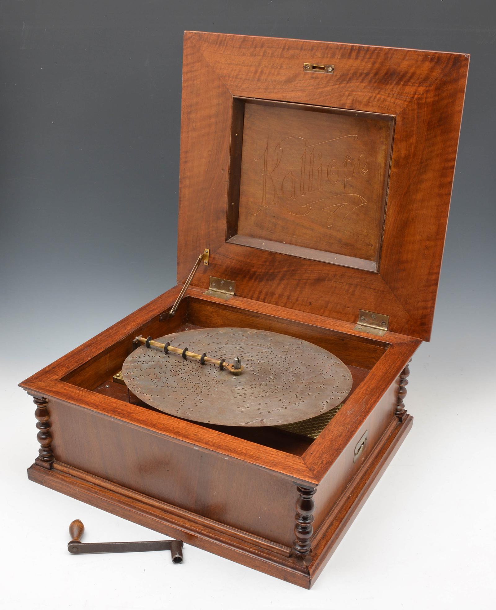Kalliope music box with 19 discs: Kalliope music box with discs, including (19) 13 1/4" discs and original crank, comb with 1 tooth missing as shown. Refinished case measures 8" t x 18 1/4" w x 18" d, plays but needs cleaning.