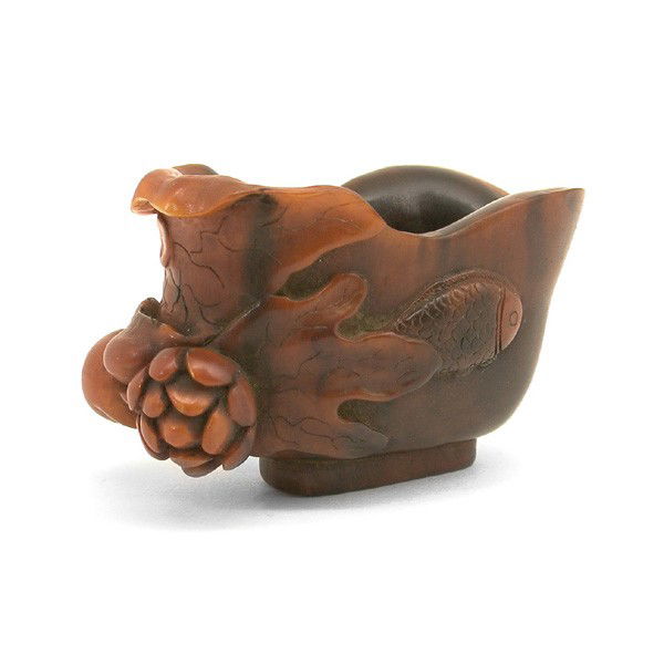 Chinese Rhinoceros Horn Lotus Form Libation Cup: HORN. Chinese Rhinoceros Horn Lotus Form Libation Cup, 18th/19th century. The cup with gently flared rim and a flowering lotus stem rising from the foot and its furled lotus leaf wrapping around the c