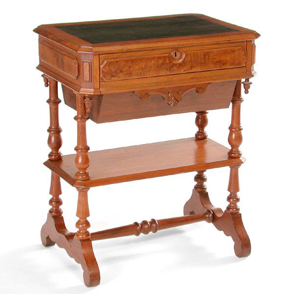 American Victorian Walnut Sewing Table: TABLE. American Victorian walnut sewing table having inset leather top, two drawers including a yarn compartment, a shelf below, the whole rising on spool turned legs, 29"h x 24"w x 17"d. In very good