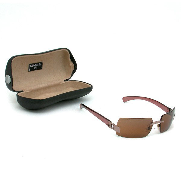 Brown Chanel Sunglasses: SUNGLASSES. Brown Chanel sunglasses with Chanel logo at temples, retains original case, good condition.