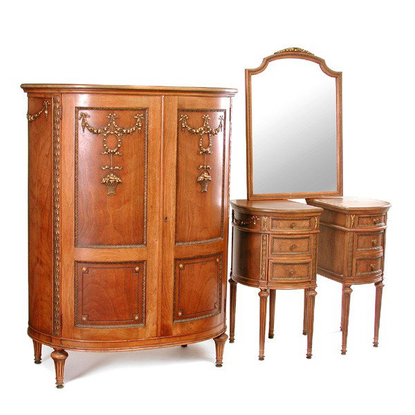 Louis XVI Style Walnut Bedroom Set: Louis XVI style walnut bedroom set having applied wreath and swag carving decoration, including a demilune armoire, a pair of three drawer nightstands, and a mirror, armoire 55"h x 42"w x 25"d. In ver