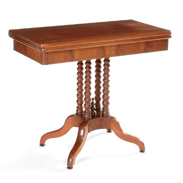 19th Century Honduran Mahogany Games Table: GAMES TABLE. 19th century Honduran mahogany games table. The bookmatched single board swivel top above four spool turned supports on platform and cabriole leg base. Closed: 30" h x 34" w x 17" d. Open